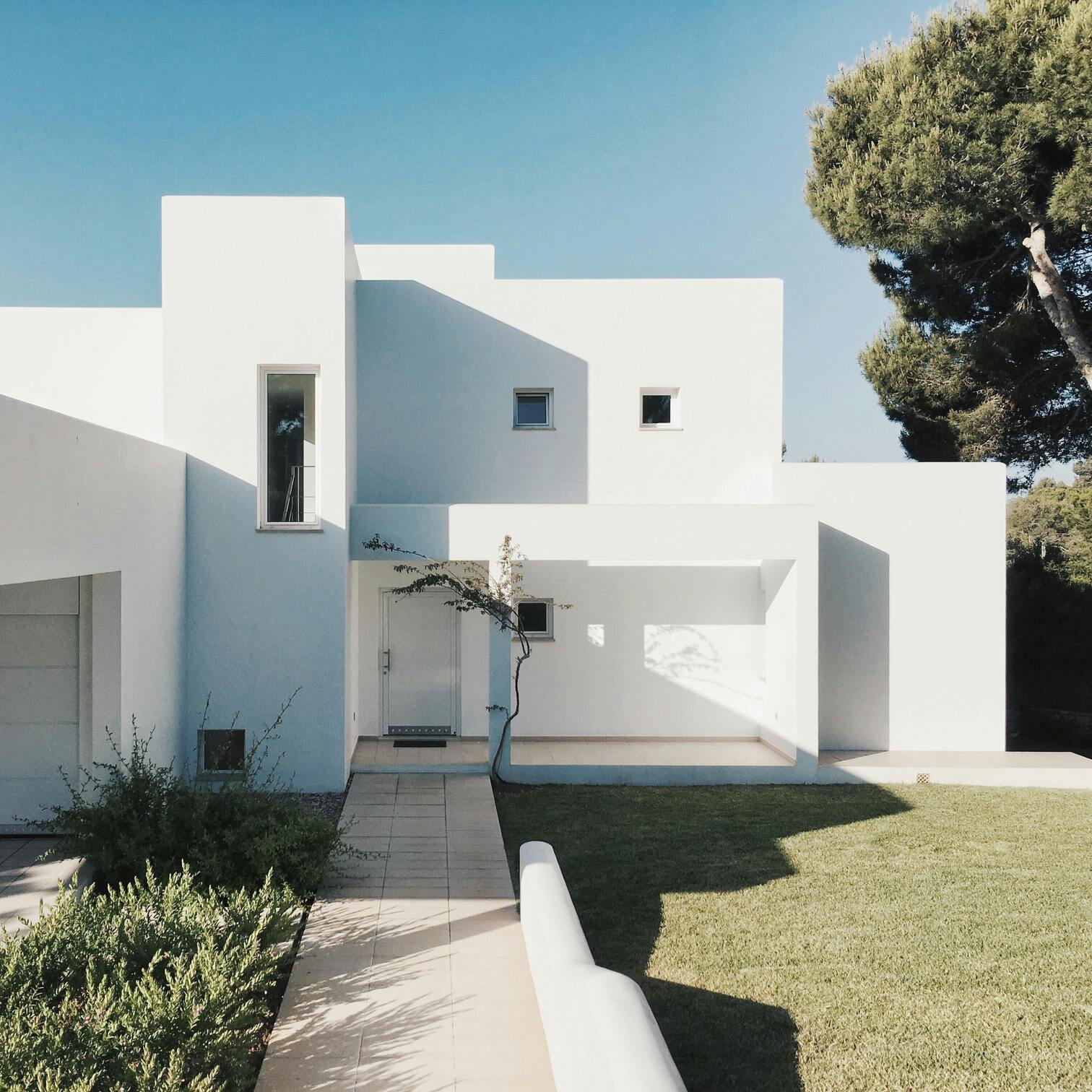 Foto einer eleganten weißen Luxusvilla mit gepflegtem Rasen – hochwertige Luxusimmobilie 