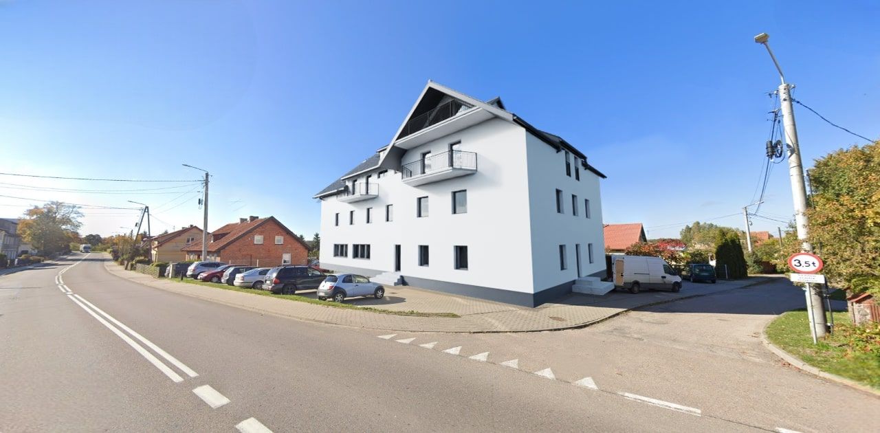 Fotomontage eines Fassadenentwurfs für ein Mehrfamilienhaus mit heller Fassade, graphitfarbenem Dach und dunkler Fensterrahmung
